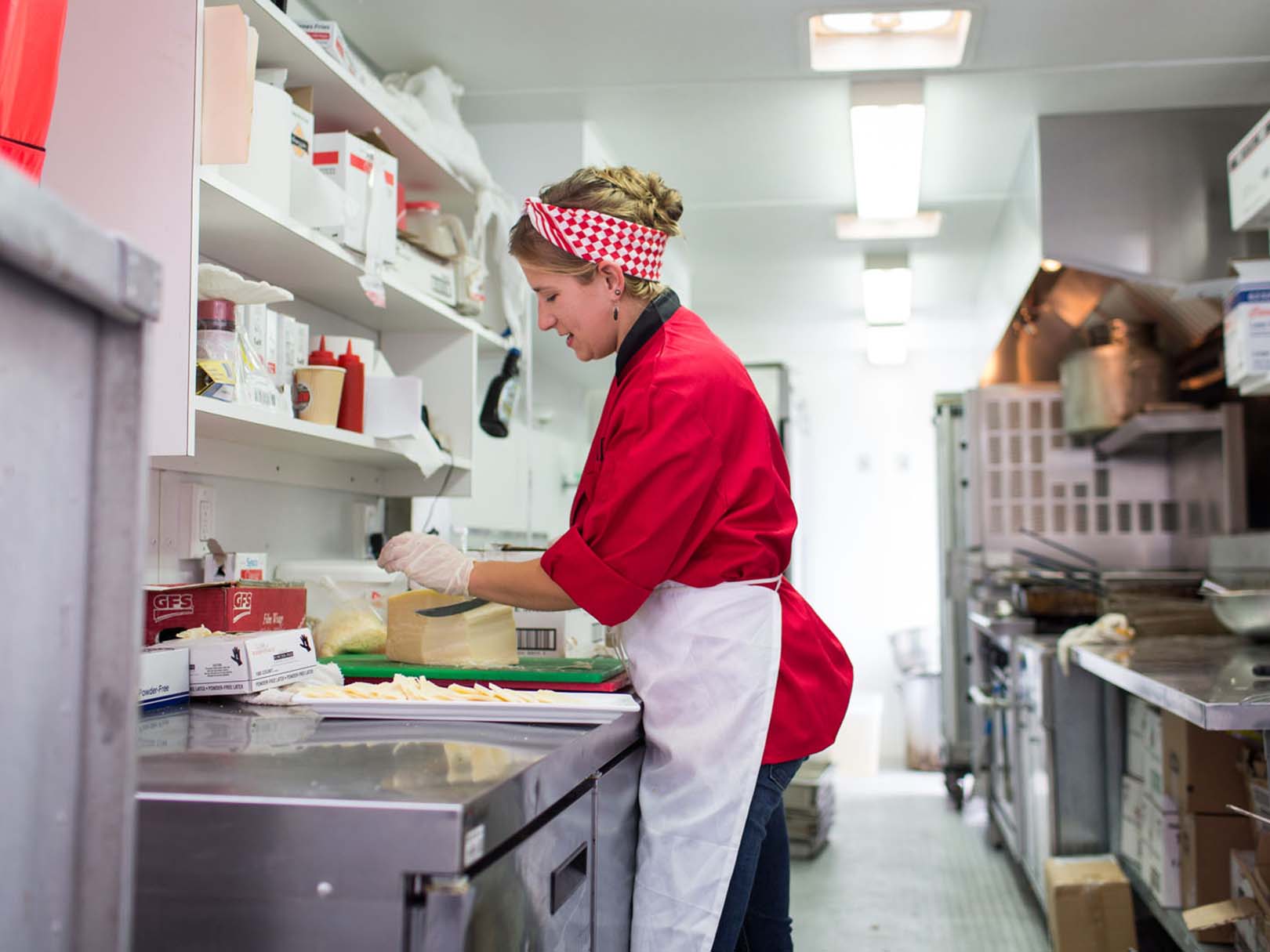 We’ll bring the food to you with our mobile kitchen! woman prepping food in mobile kitchen